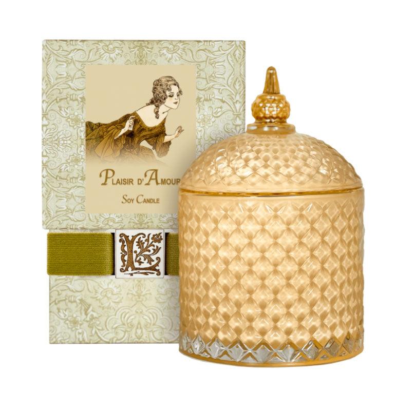 Plaisir d'Amour Luxury Soy Candle in an ornate golden glass jar with packaging.