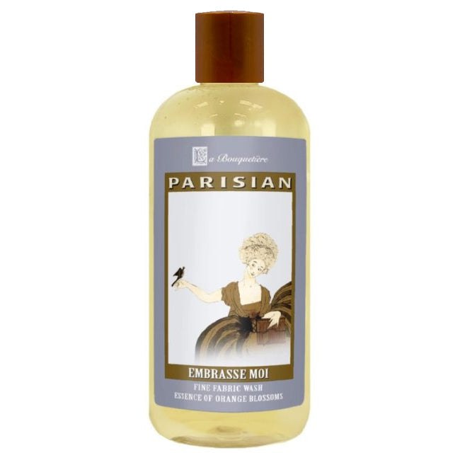 Embrasse Moi Fine Fabric Wash 19oz bottle with Parisian design, enriched with French and essential oils, plant-based ingredients.